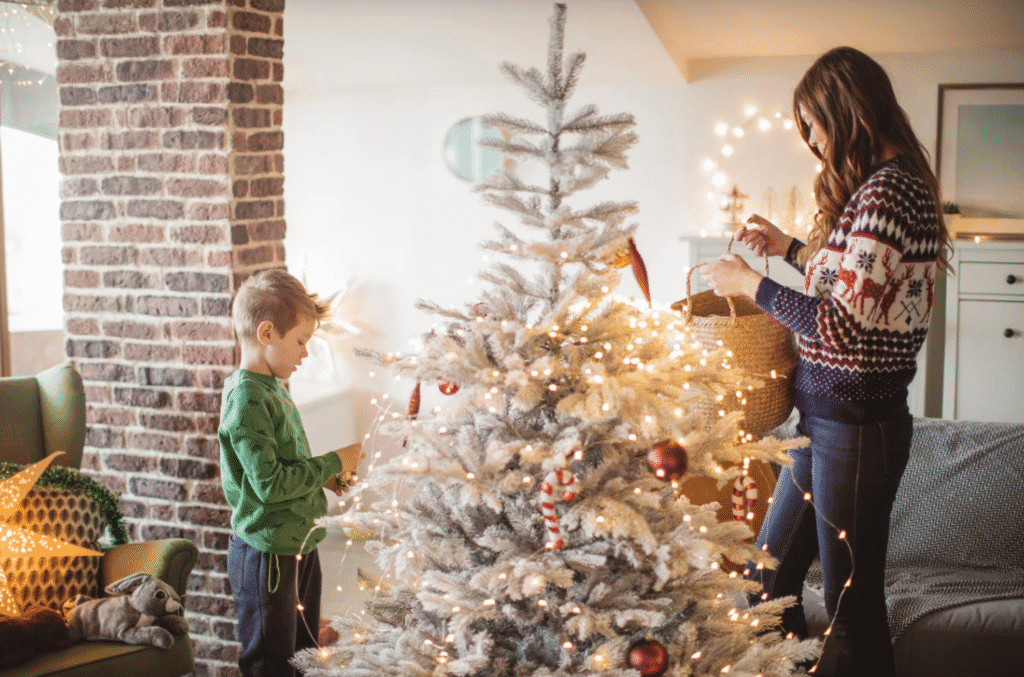 mother and young son decorating a christmas tree together