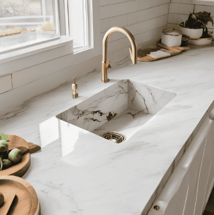 Solid surface kitchen sink in a marble white and grey style with gold tap and plug features
