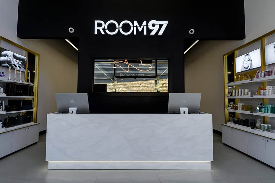 front desk of a salon, grand and luxury with white solid surface as the desk with macs on the desk