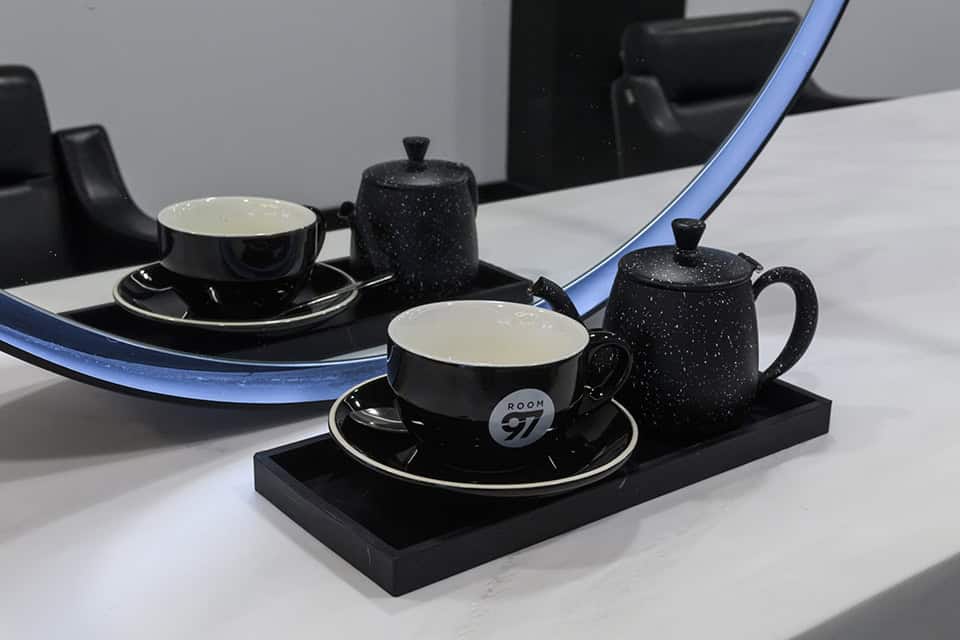 mug and teapot sat on the white solid surface worktop by a mirror in the salon